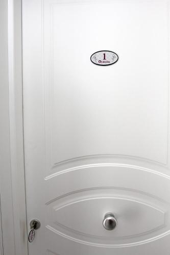 a white door with a clock on it at Orchidea Rooms & Suites in Civitanova Marche