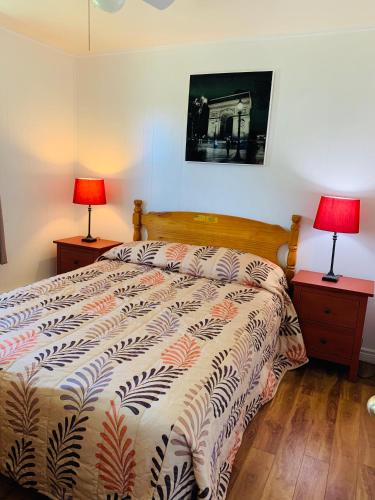 a bedroom with a bed with two lamps on tables at Fair Isle Motel in Charlottetown