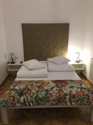 ein Schlafzimmer mit einem Bett und zwei Kissen darauf in der Unterkunft Casa Karola Ház in Băile Tuşnad