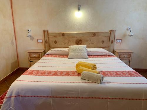 a bedroom with a large bed with two towels on it at Canne al Vento in Galtellì