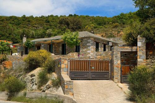 a stone house with a gate and a driveway at Pelion Goddess Villas in Agios Georgios Nilias