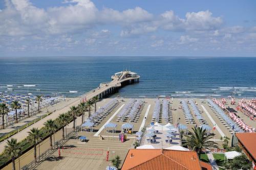 a beach with a pier and a bunch of umbrellas at Casa Maria in Camaiore