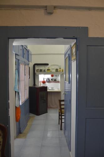 a hallway with a blue door leading to a kitchen at Appartamento in palazzina storica / Oberdan Suites in Alberobello