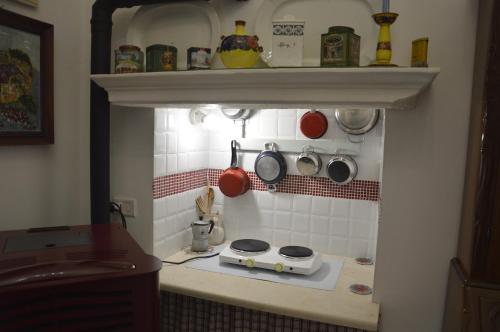 a kitchen with a stove and some pots and pans at Appartamento in palazzina storica / Oberdan Suites in Alberobello