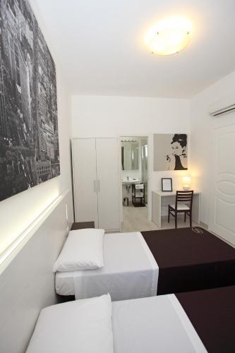 a bedroom with two beds and a dining room at Orchidea Rooms & Suites in Civitanova Marche