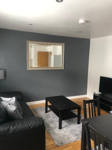 a living room with a couch and a table and a mirror at Modern Apartment in Trendy Dalston in London