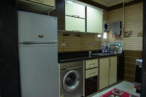 a kitchen with a refrigerator and a washing machine at City Square Bay View in Alexandria