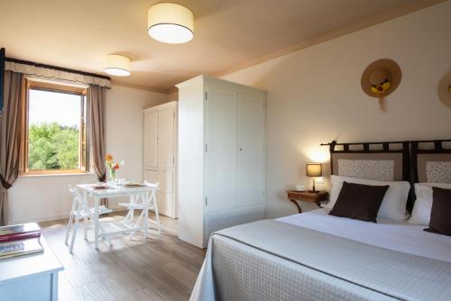 a bedroom with a bed and a table and a window at I Pianelli in Murlo