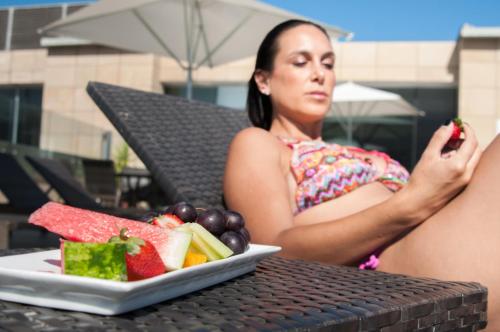 a woman sitting at a table with a plate of fruit at Enjoy Antofagasta in Antofagasta