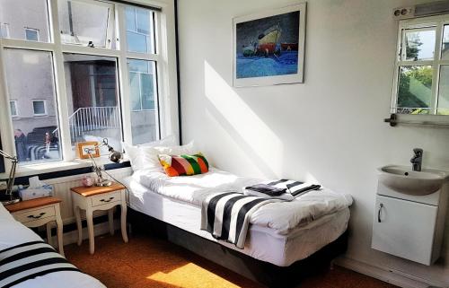 een kleine kamer met een bed en een raam bij Refurinn Reykjavik Guesthouse in Reykjavík
