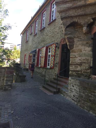 a woman walking past a stone building with colorful windows at Moderne Wohnung im Rhein-Main-Gebiet in Idstein
