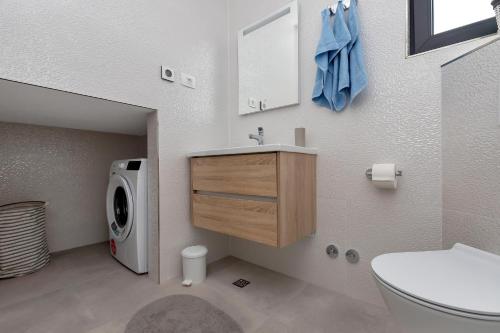 a bathroom with a sink and a washing machine at Central Beach Apartments in Tučepi