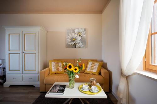a living room with a couch and a vase of flowers on a table at I Pianelli in Murlo