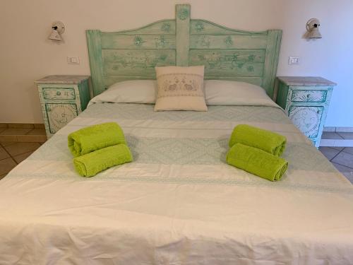 a bed with two lime green pillows on it at Canne al Vento in Galtellì