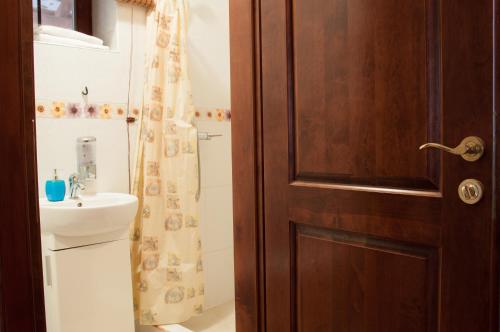 a bathroom with a wooden door and a sink at Домик в горах in Turʼya Paseka