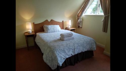 a bedroom with a bed with two towels on it at Lodge in Portumna Ireland in Portumna