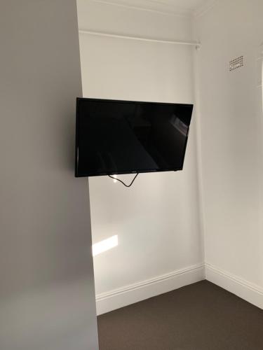 a white wall with a black and white television at Garden Hotel in Dubbo
