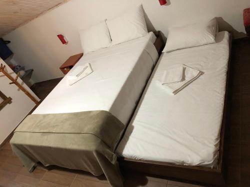 a bed in a room with white sheets and pillows at João e Maria Restaurante e Chalés in Tiradentes