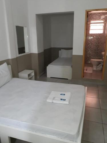 Cette petite chambre comprend un lit et un miroir. dans l'établissement Hotel Aruba, à Curitiba