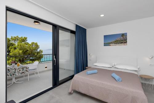 a bedroom with a bed and a balcony at Central Beach Apartments in Tučepi