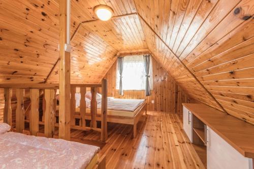 a log cabin with a bed in the attic at Cavilla - Pokoje i Apartamenty in Sztutowo