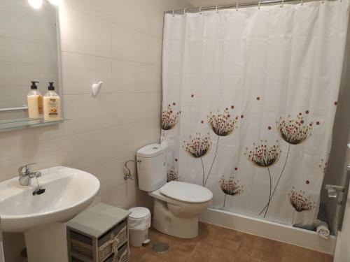 a bathroom with a toilet and a sink and a shower curtain at Apartamentos la villa 4 in San Sebastián de la Gomera