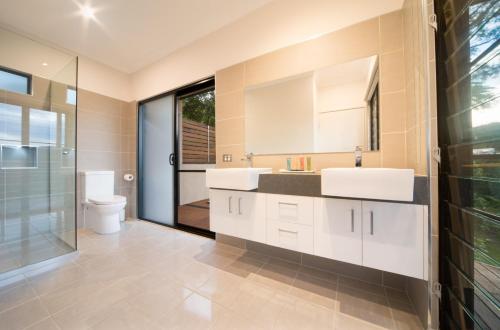 a bathroom with two sinks and a toilet at Seclude Rainforest Retreat in Palm Grove