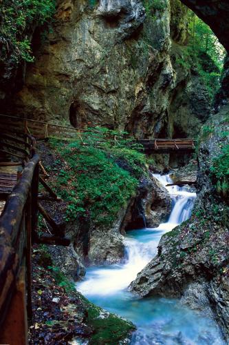 a bridge over a river in a rocky canyon at Hotel Jenbacherhof B&B in Jenbach