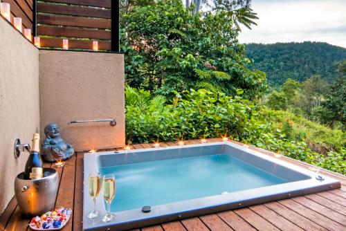 
a bath tub sitting next to a pool of water at Seclude Rainforest Retreat in Palm Grove
