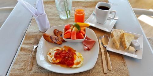 a plate of breakfast food with eggs fruit and toast at Hotel Casona del Lago in Flores