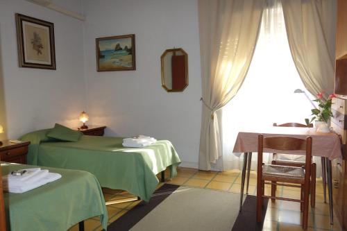 Zimmer mit 2 Betten, einem Tisch und einem Fenster in der Unterkunft B&B Rome Downtown Deluxe in Rom