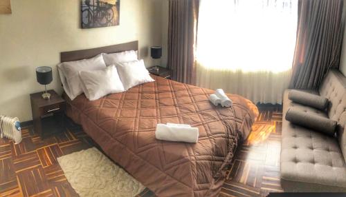a bedroom with a large bed with two towels on it at Cusco Inloft en pareja in Cusco