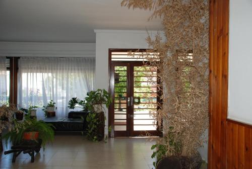 un salón con puerta y algunas plantas en el Hotel Nuevo Horizonte de Villa Gesell