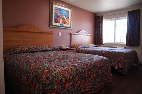 a hotel room with two beds and a window at Capri Motel Santa Cruz Beach Boardwalk in Santa Cruz