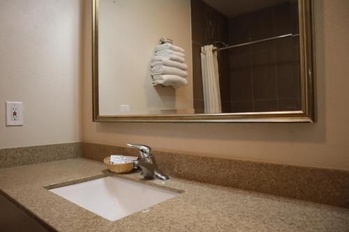a bathroom sink with a mirror and a towel at Capri Motel Santa Cruz Beach Boardwalk in Santa Cruz