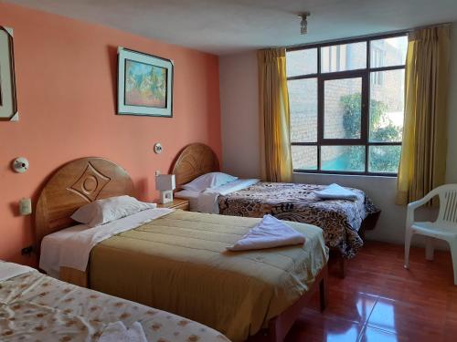 a hotel room with two beds and a window at Waikycha Hostal in Arequipa
