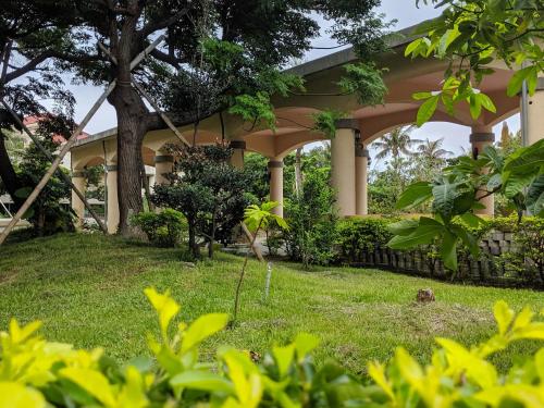 a house with a tree in the yard at Howard Kenting Wonder House in Kenting