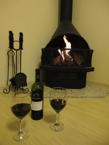 two glasses of wine sitting on a table with a fireplace at Apartamento Baviera in Canela