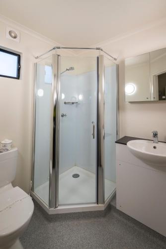 a bathroom with a shower and a toilet and a sink at Victoria Village in Katherine
