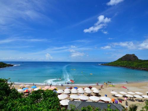 a beach with umbrellas and people in the water at Howard Kenting Wonder House in Kenting