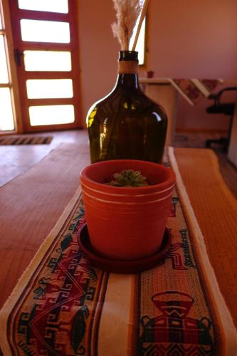a bottle and a pot on a table with a bowl at Casa Ckelar Atacama in San Pedro de Atacama