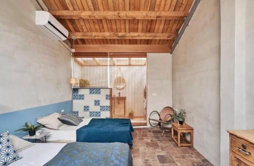 屏東市的住宿－大厝護龍，一间卧室设有两张床和木制天花板