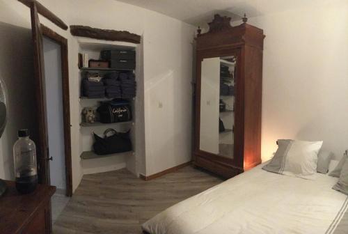 1 dormitorio con cama y espejo grande en La charmante **** Maison Cap Corse, Tomino, en Mandolacce