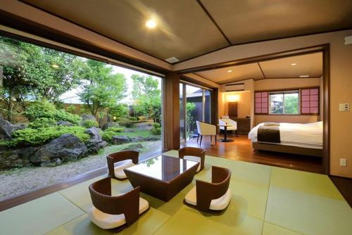 1 dormitorio con 1 cama y sala de estar en Okuyado Buaiso en Yufuin