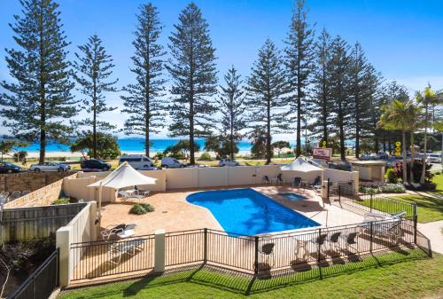 an image of a swimming pool with trees in the background at Columbia Beachfront Apartments on Rainbow Bay in Gold Coast