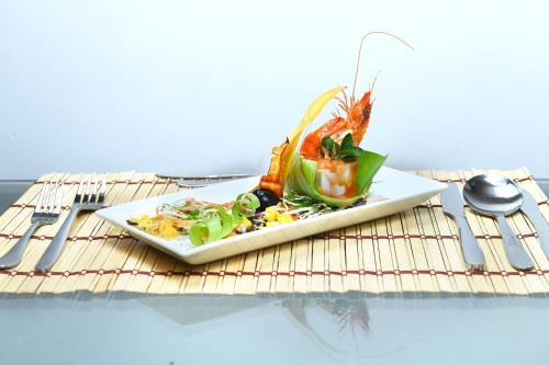 a plate of food on a table with fork and knife at Muwan Palassa Resort in Minneriya