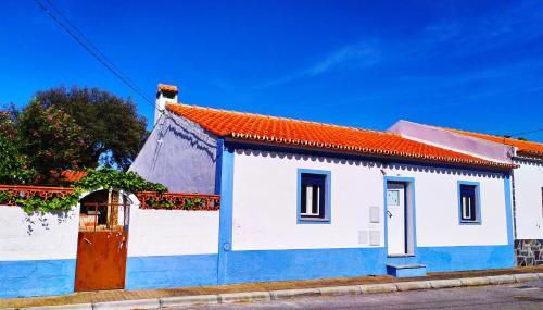 a blue and white building with a red roof at Casa Menir in Monsaraz