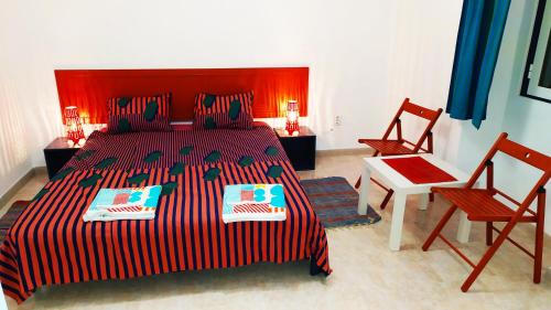 a bedroom with a large bed and two chairs at Casa Menir in Monsaraz