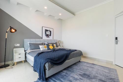 a bedroom with a bed with a blue blanket at Sanya Sun Seaview Apartment in Sanya