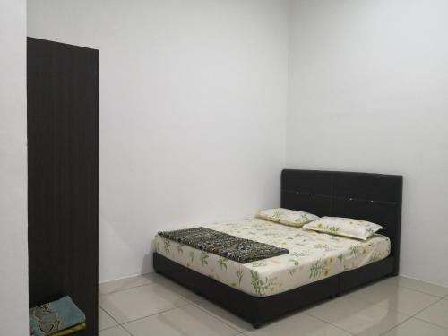 a bed in a room with a white wall at Aliya Villa Pulau Langkawi House in Kuah